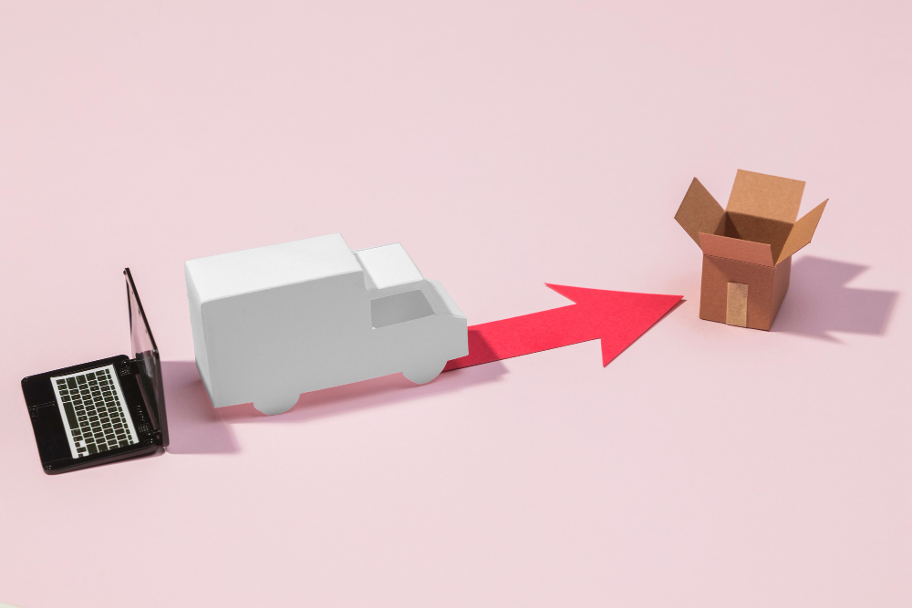 Caminhão ao lado de um notebook seguindo a seta que leva as caixas, representando a logística reversa no e-commerce.